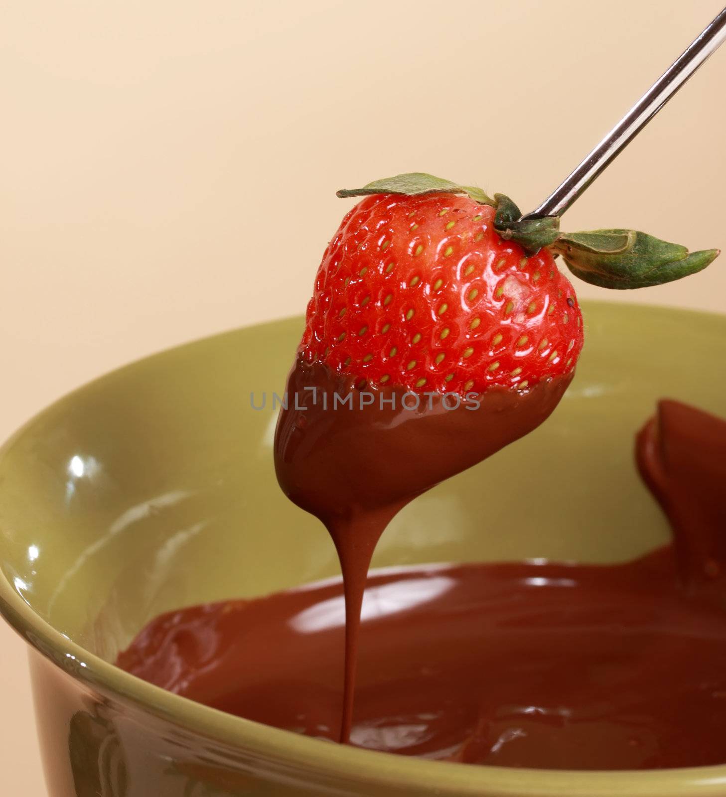 chocolate fondue kit and fresh strawberry, beige background