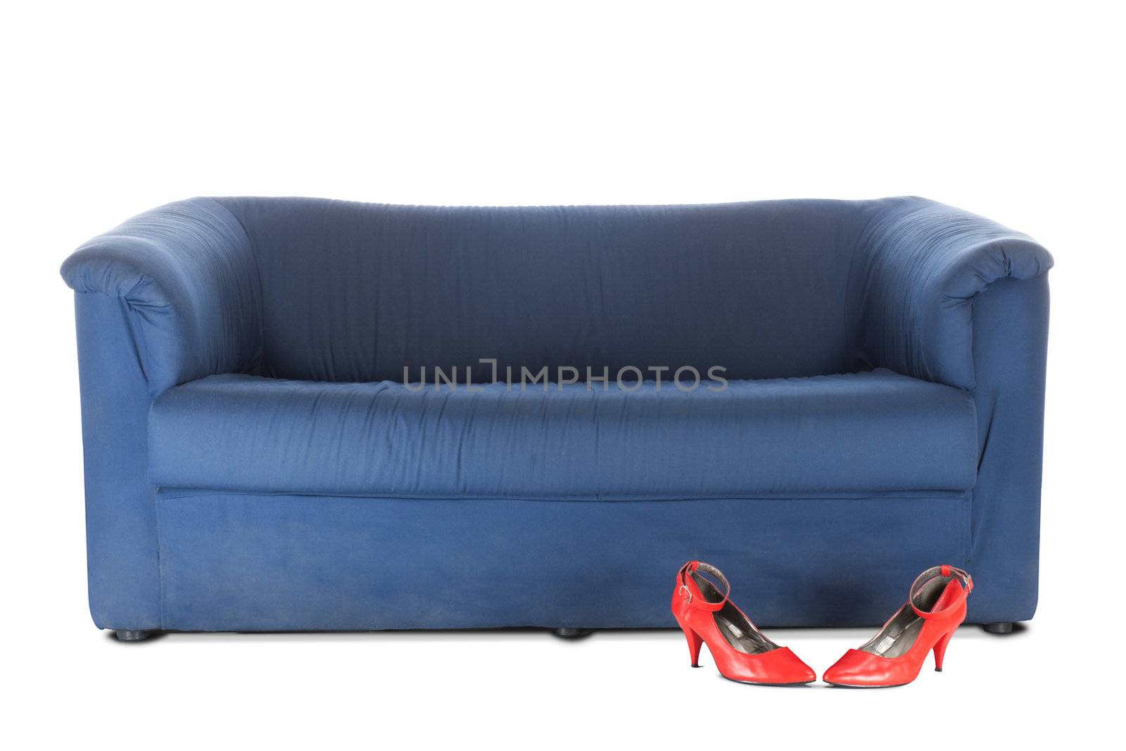 Blue textile couch and red female shoes. Conceptual photo. Isolated over white