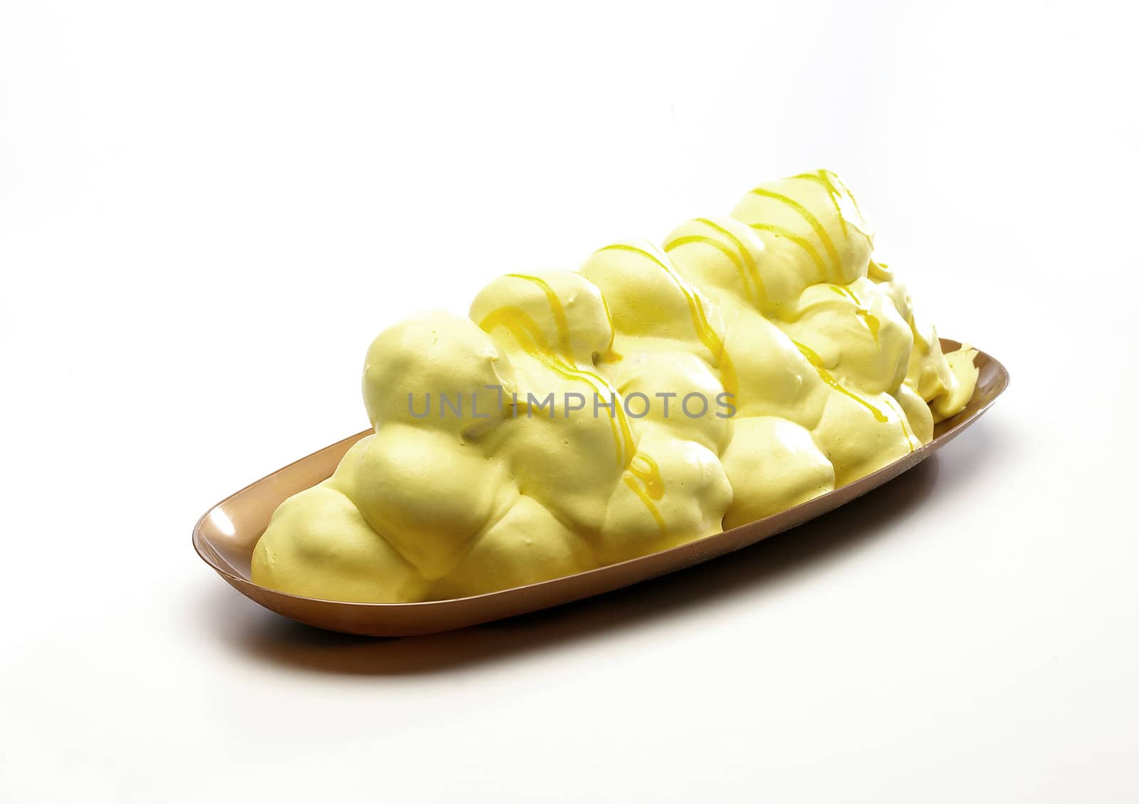 Profiteroles stuffed with cream and topped with lemon sauce 