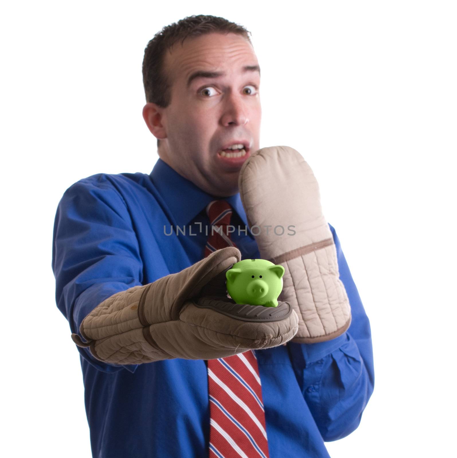 Concept image a risky investment featuring a businessman holding a small piggy bank with oven mitts, isolated against a white background