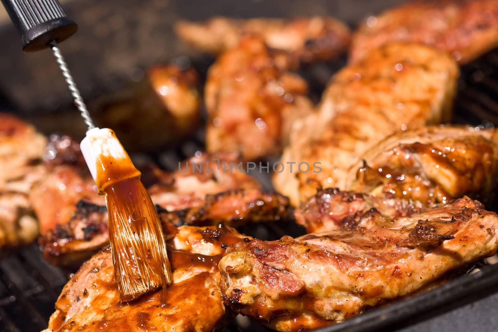 barbecue chicken on the grill with sauce