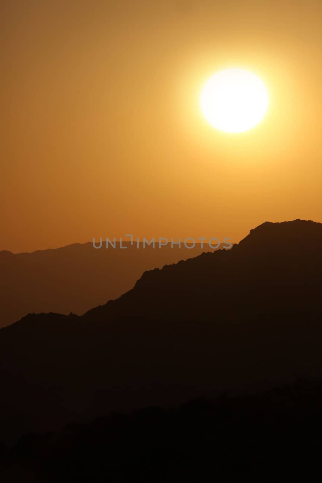 Vertical Silhouette Sunrise of Hazy Misty Mountains With Warm Colors