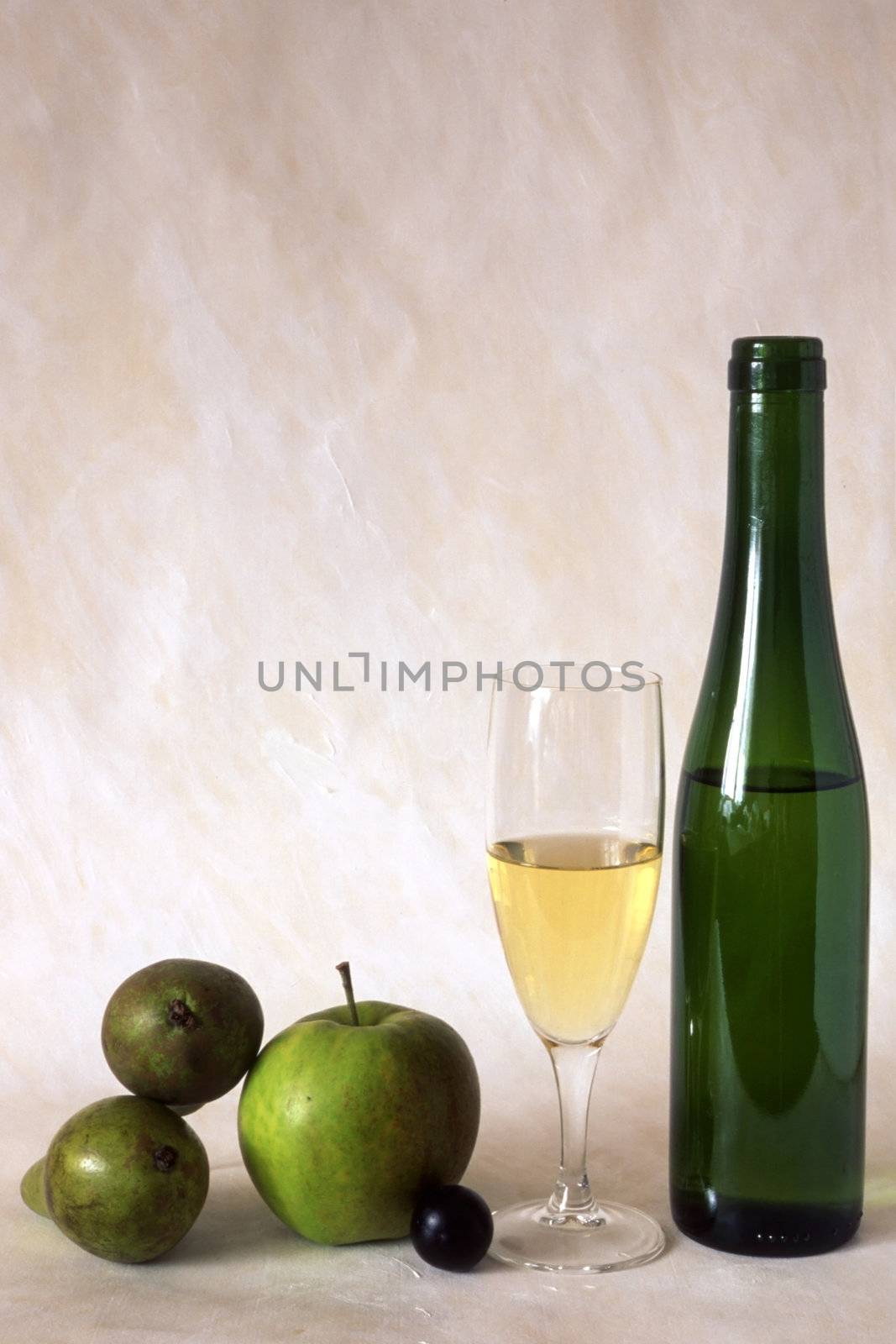 A glass of white wine and fruits isolated on painted background