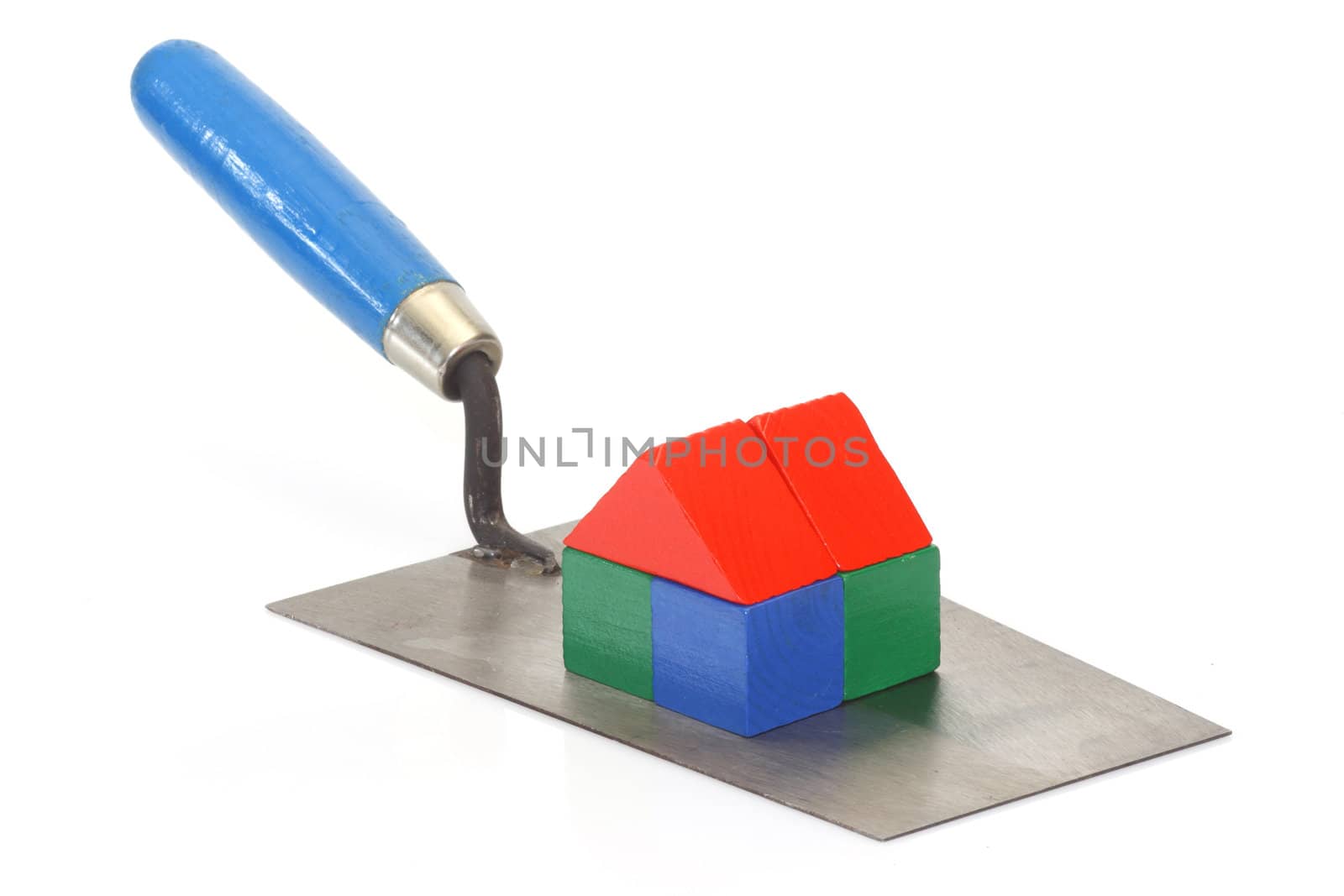 Trowel with toy bricks on bright background