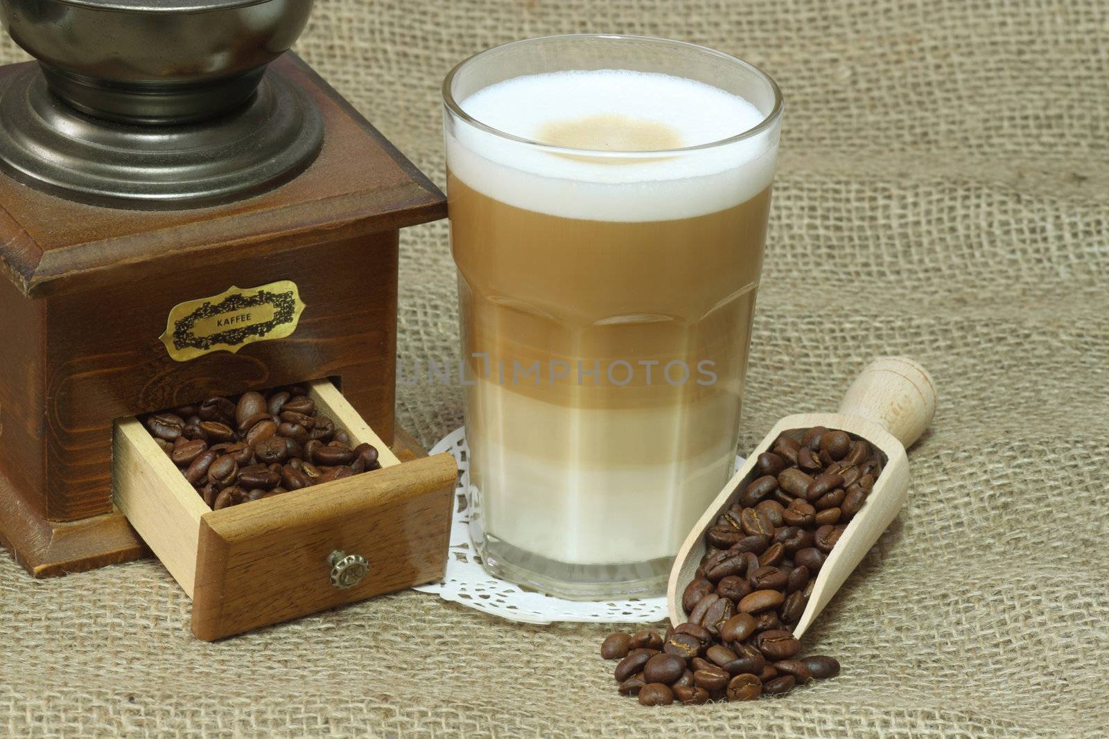 Latte Macchiato in glass with coffee grain on brown background