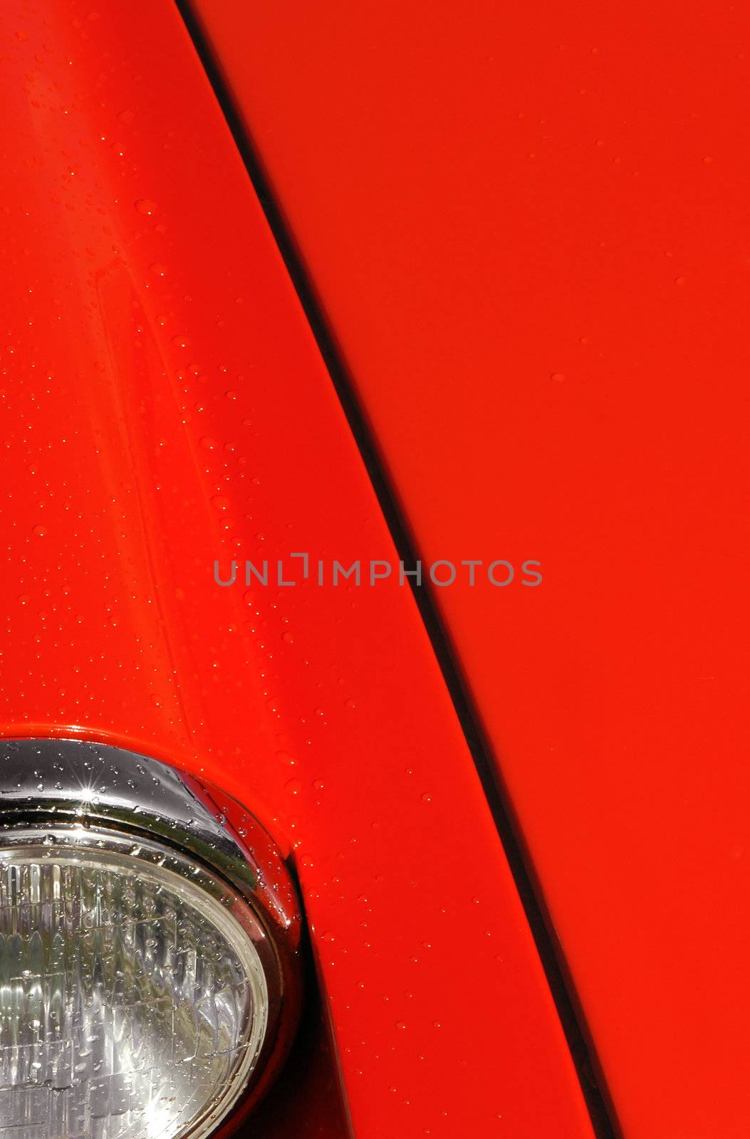 red sports car hood with some raindrops on panels