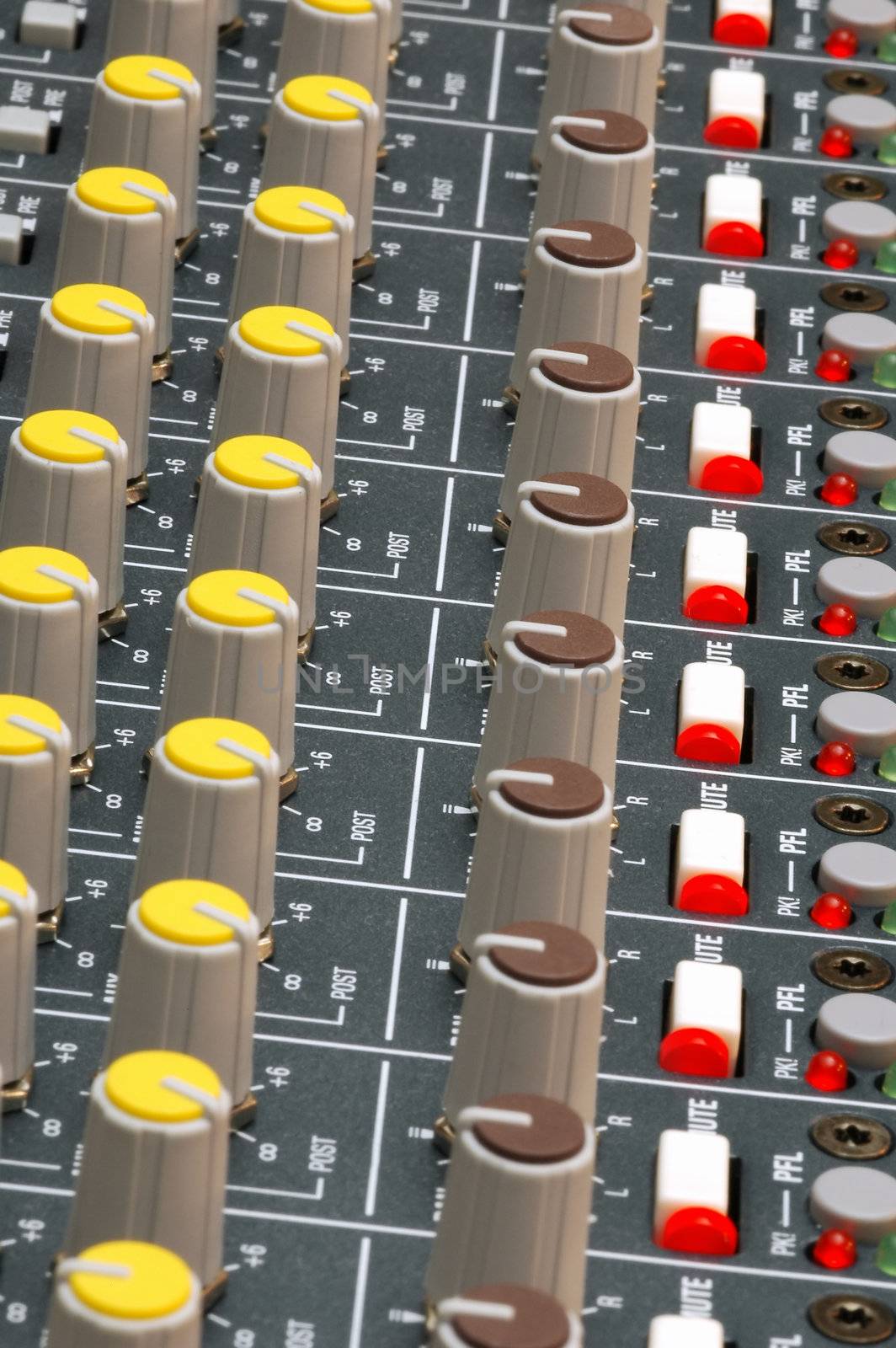 dials and led lights on a soundboard mixer