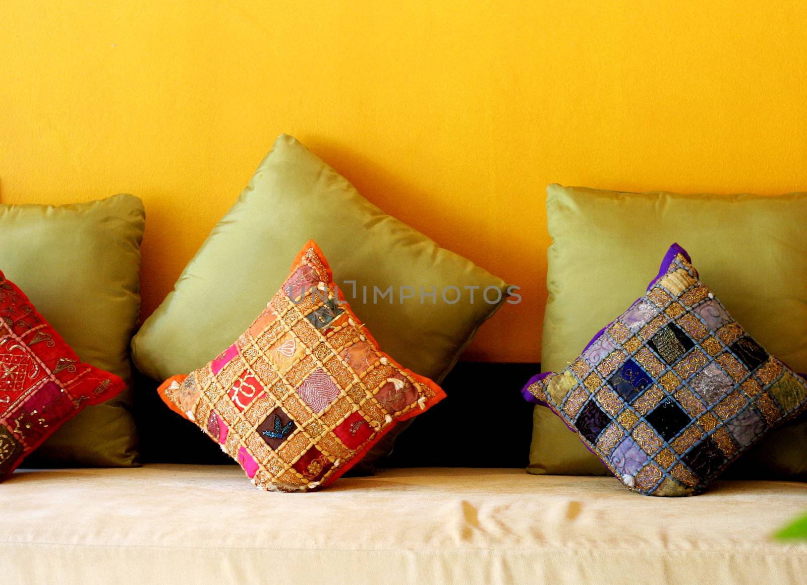 Bright sofa covered with ethnic pillows - home interiors.