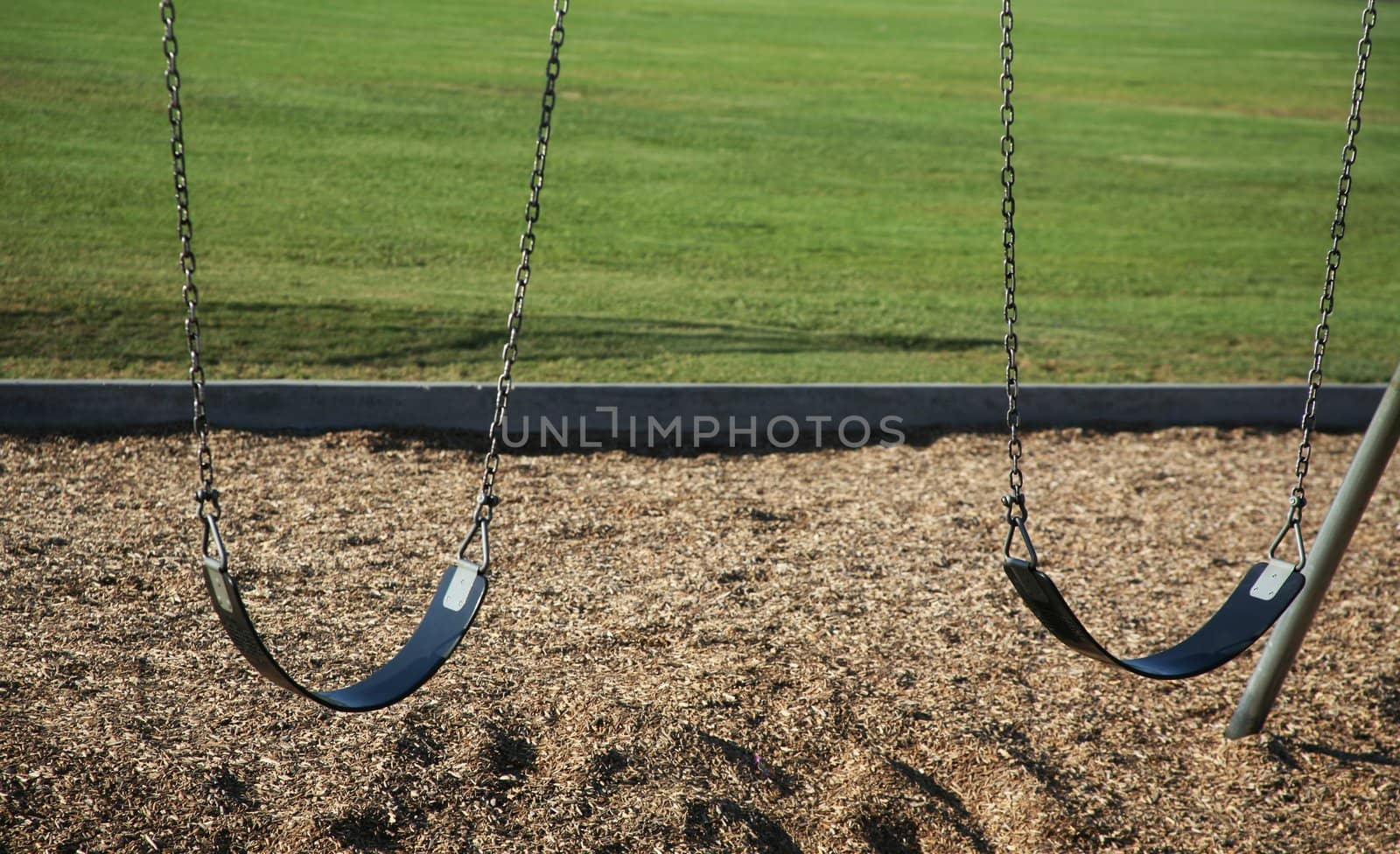 Two swings with grass background