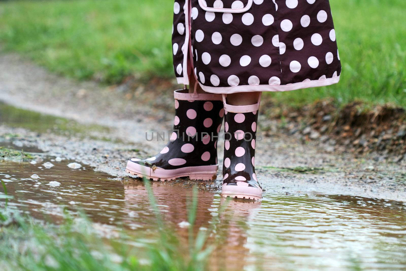 Child's feet playing in a mud puddle. 
