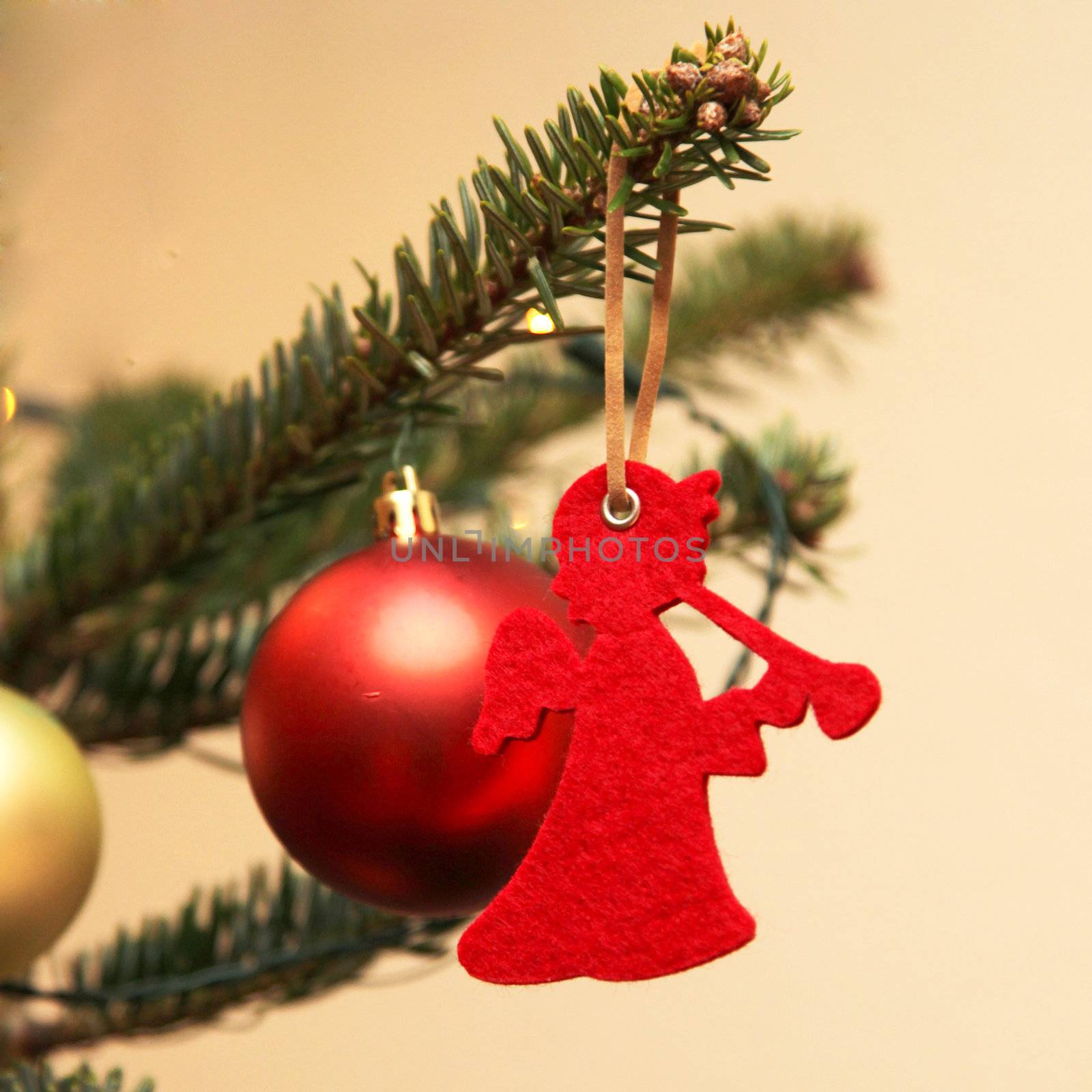 Red Christmas Angel with trumpet at the Christmas tree, close-up
