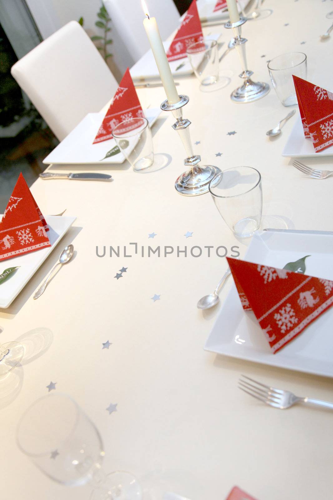 Christmas plate table decoration with stars and candles and glasses
