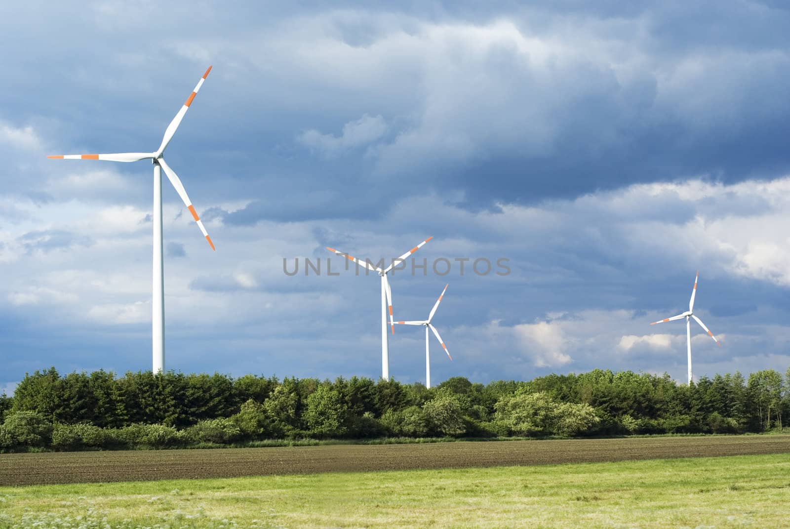 A windmill park in an open field.