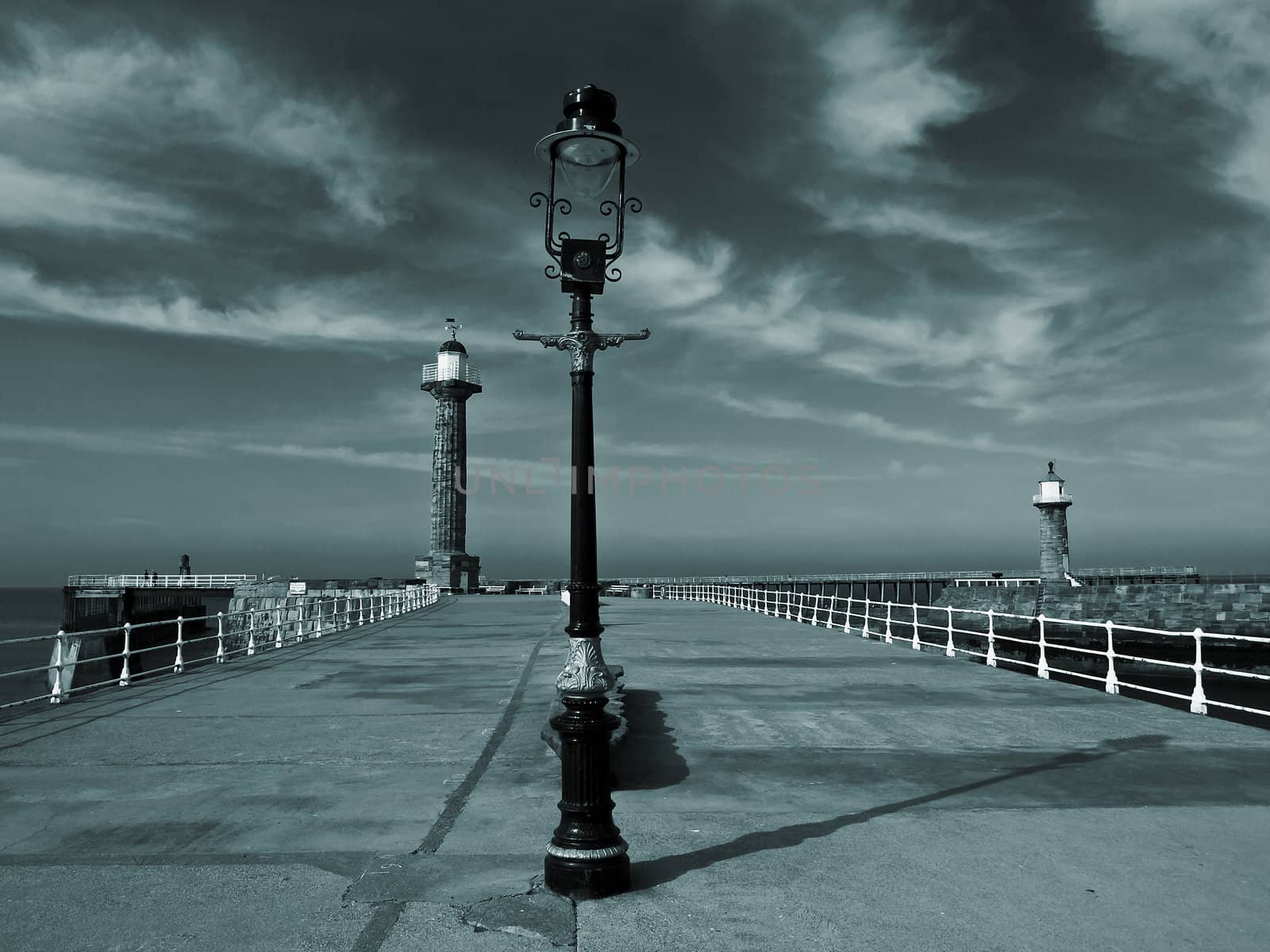 A dramattic image of Whitby Pier black and white toned