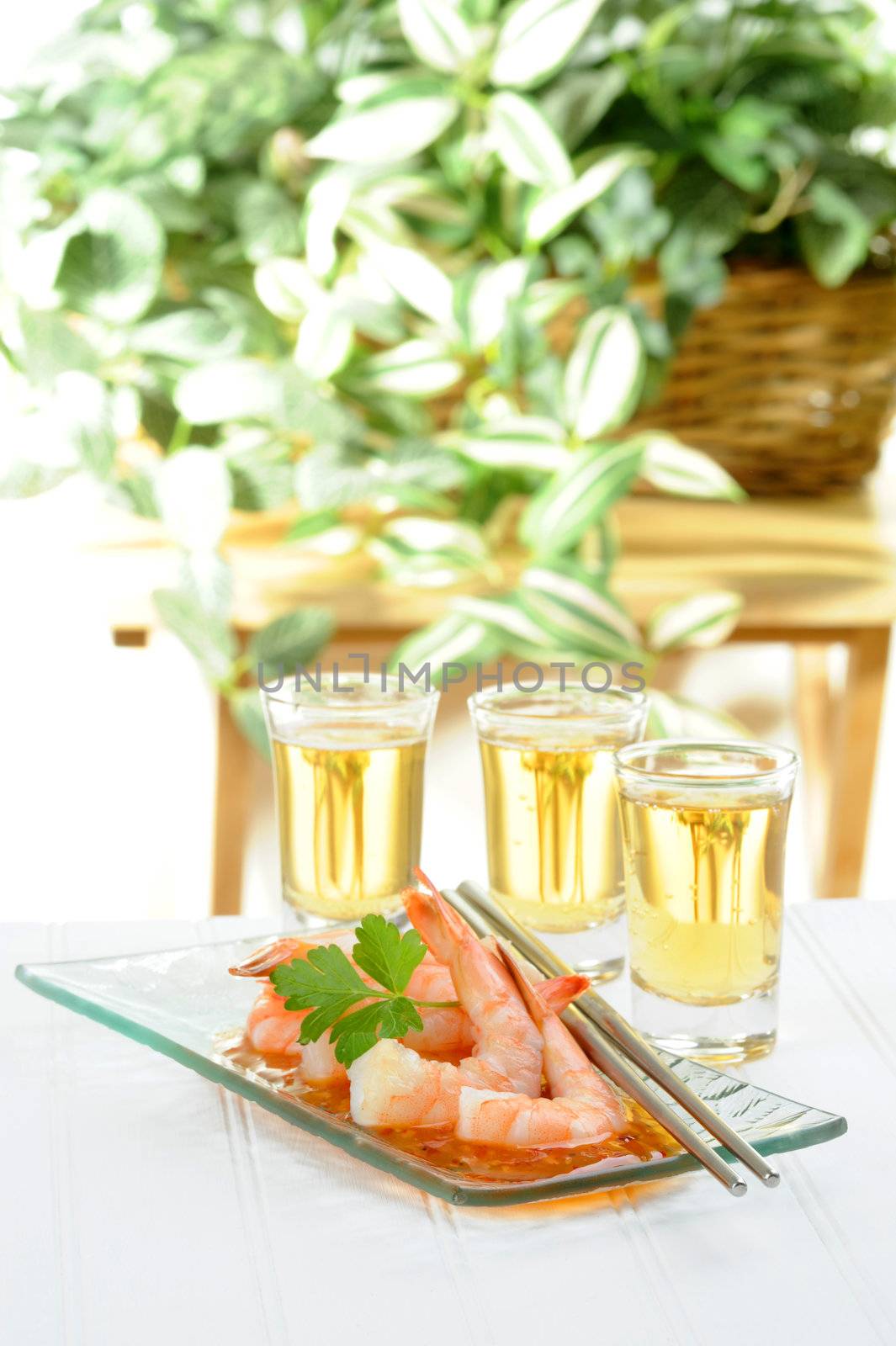 Oriental style shrimp appetizer served with small glasses of beer.