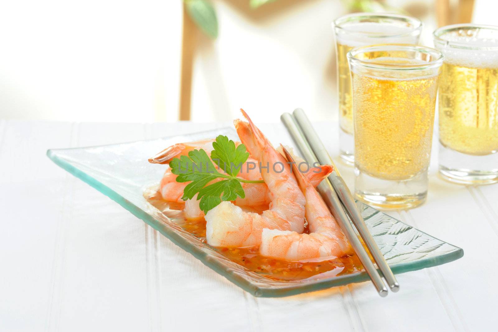 Oriental shrimp appetizer served with glasses of beer.
