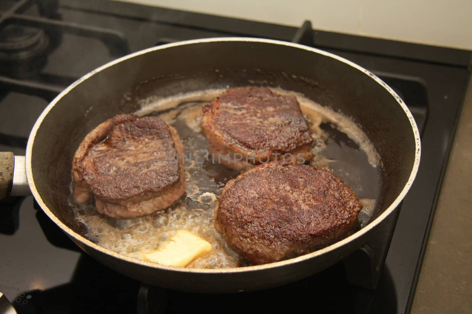 Three pieces of meat in a frying pan