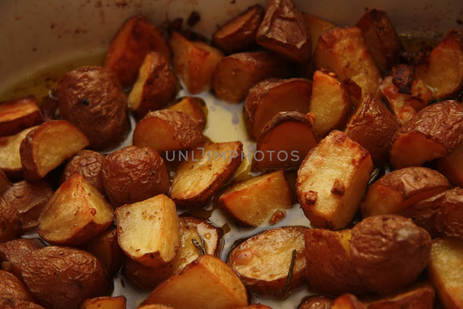A serving plate with crispy backed potatoes in oil