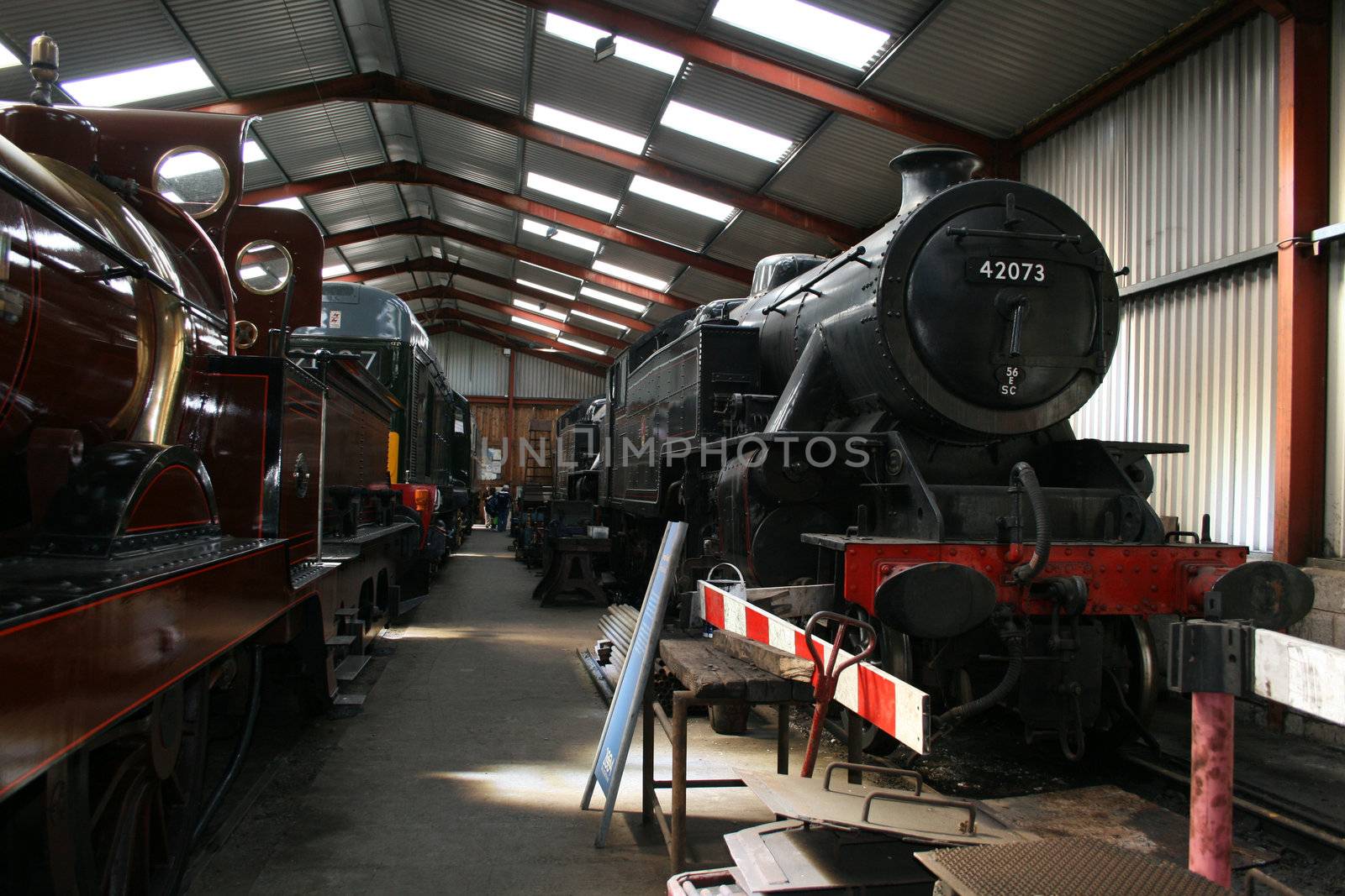 steam train in a train shed with a wooden box on board