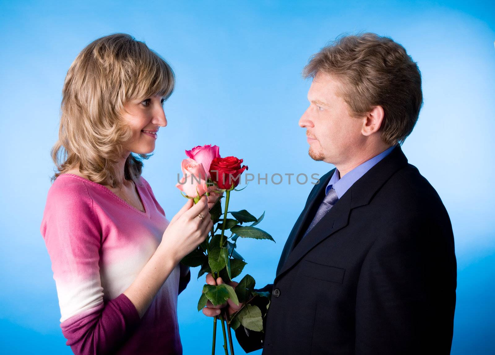 The man in a suit has presented the bouquet of flowers