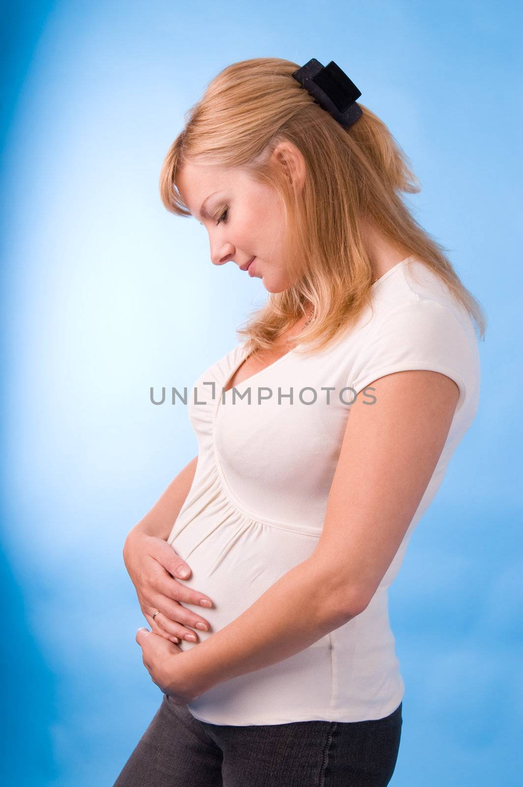 The fine pregnant woman supports hands a stomach
