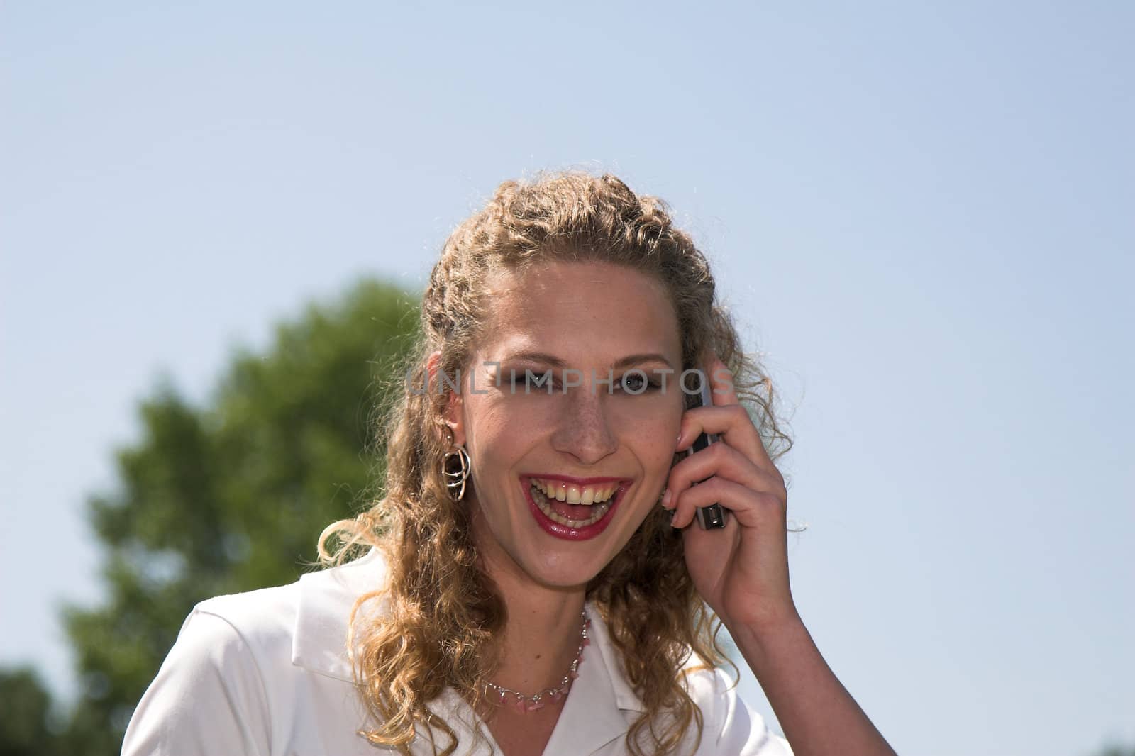 Pretty businesswoman laughing while on the phone outdoors