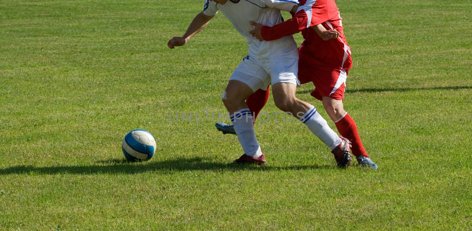 Players in the red and white form play a ball