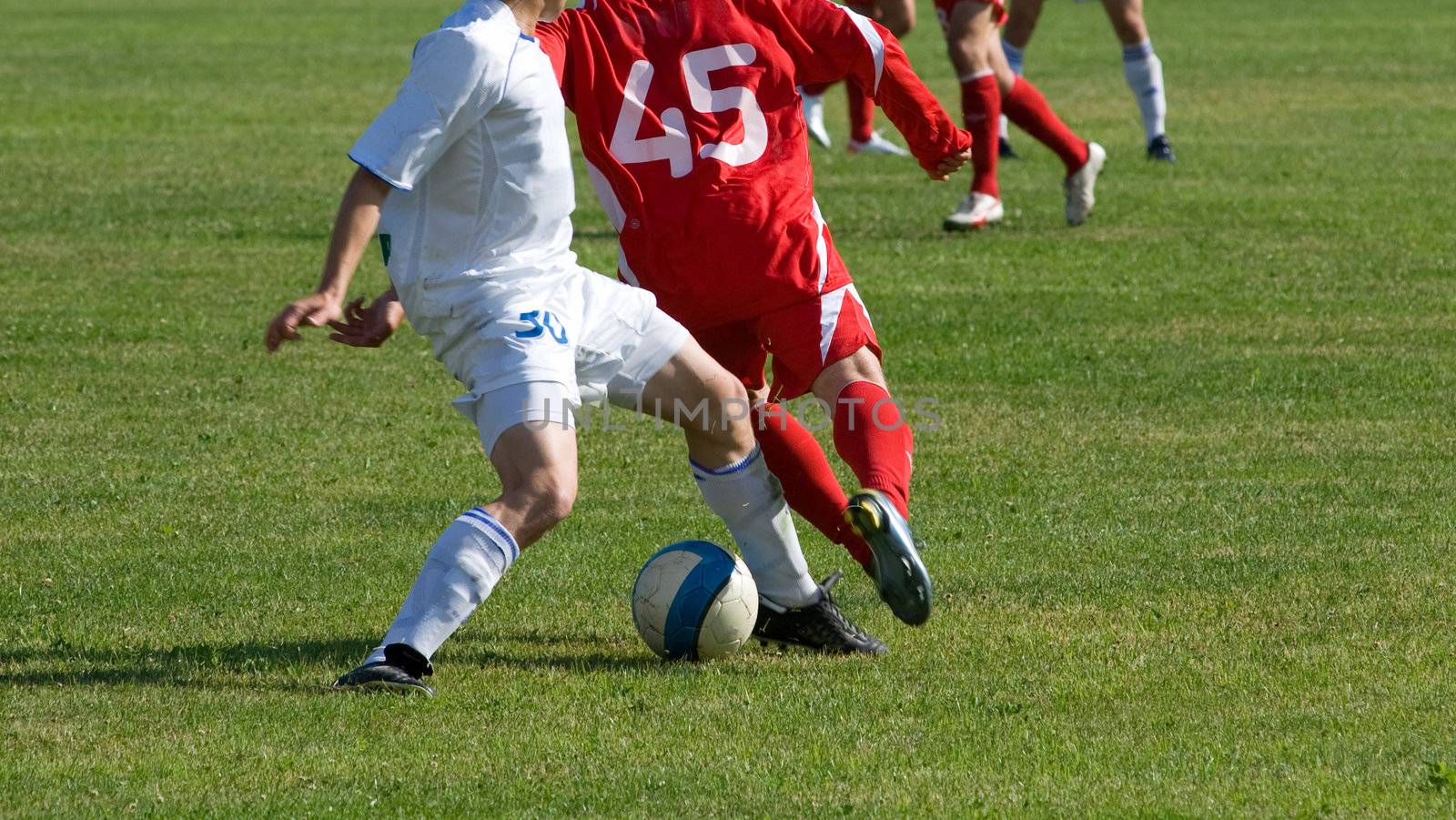 Players in the red and white form play a ball