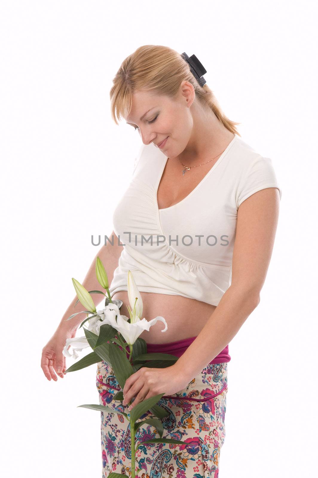 The attractive pregnant woman holds a liliy in hands