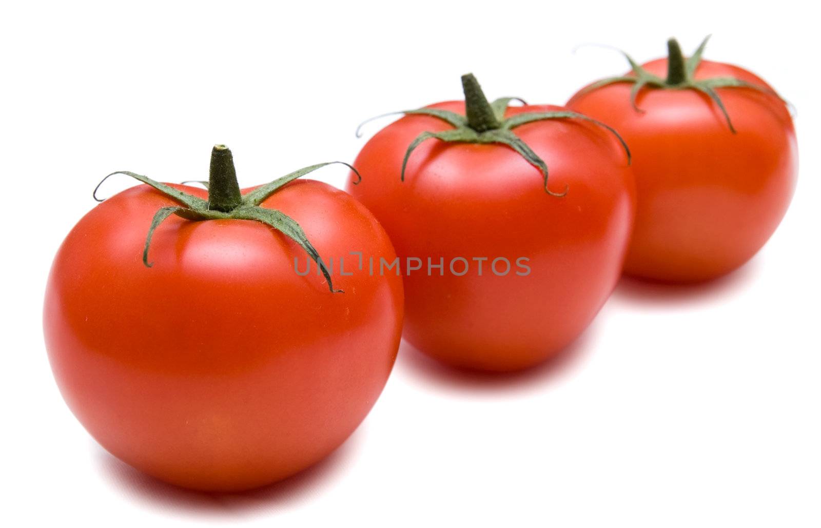 Three fresh red tomato isolated on a white background