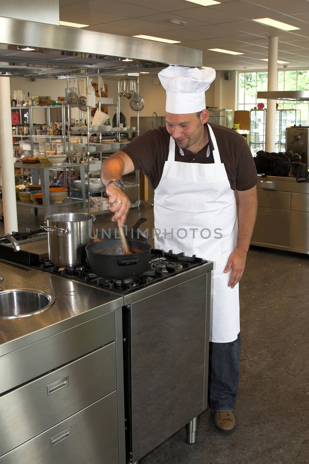Italian chef working in the kitchen, stirring the tomatoe sauce