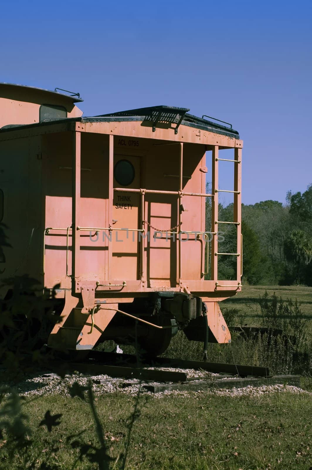 An old caboose sits on permanent tracks.