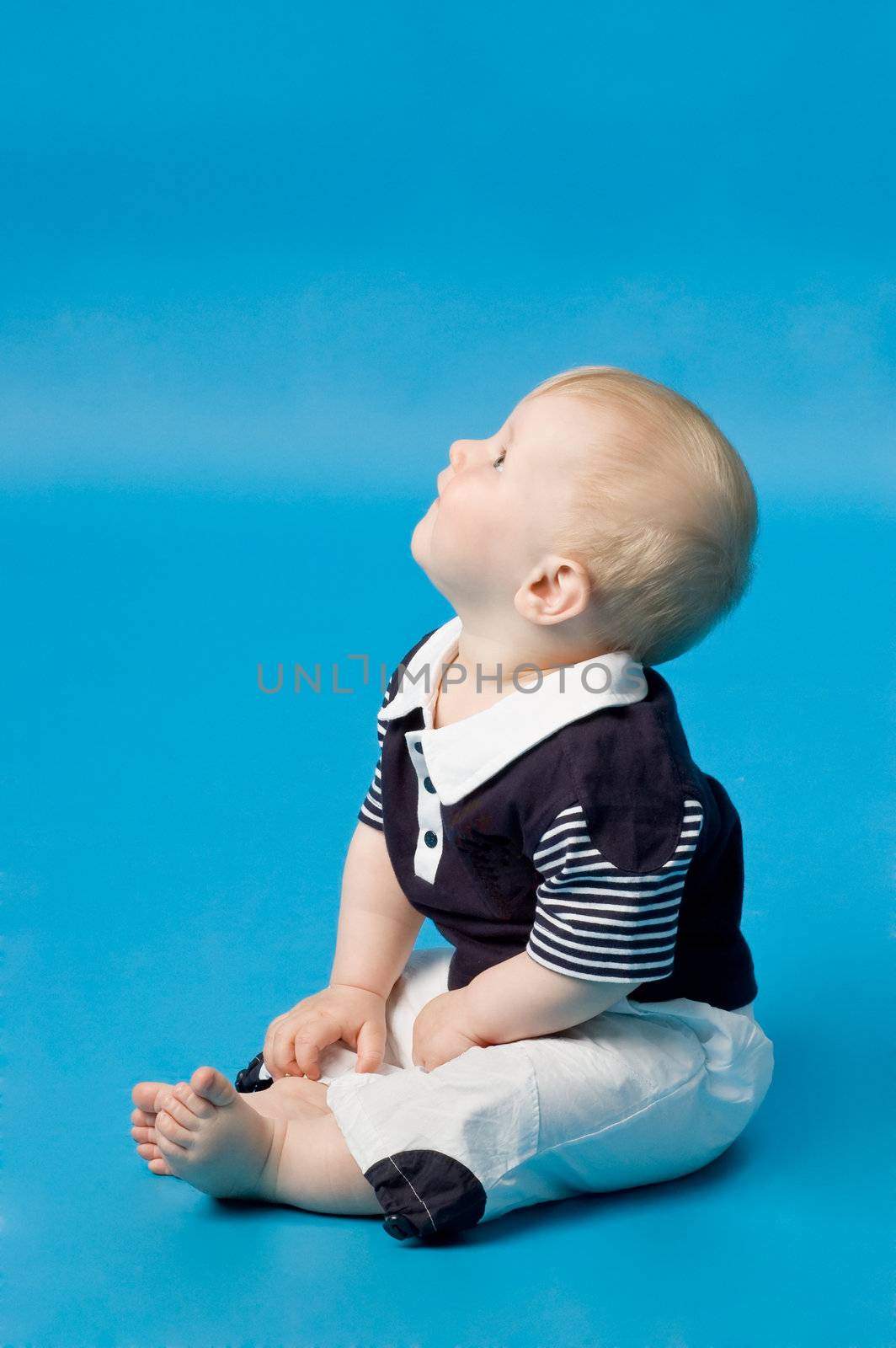 The small child in studio, on a blue background