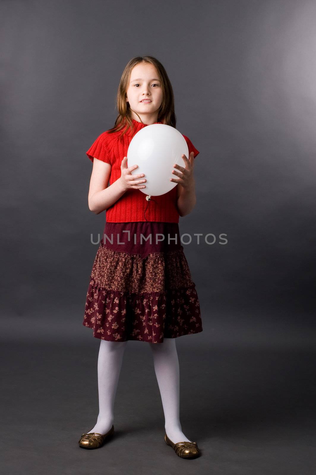 The girl with a ball in studio on a grey background