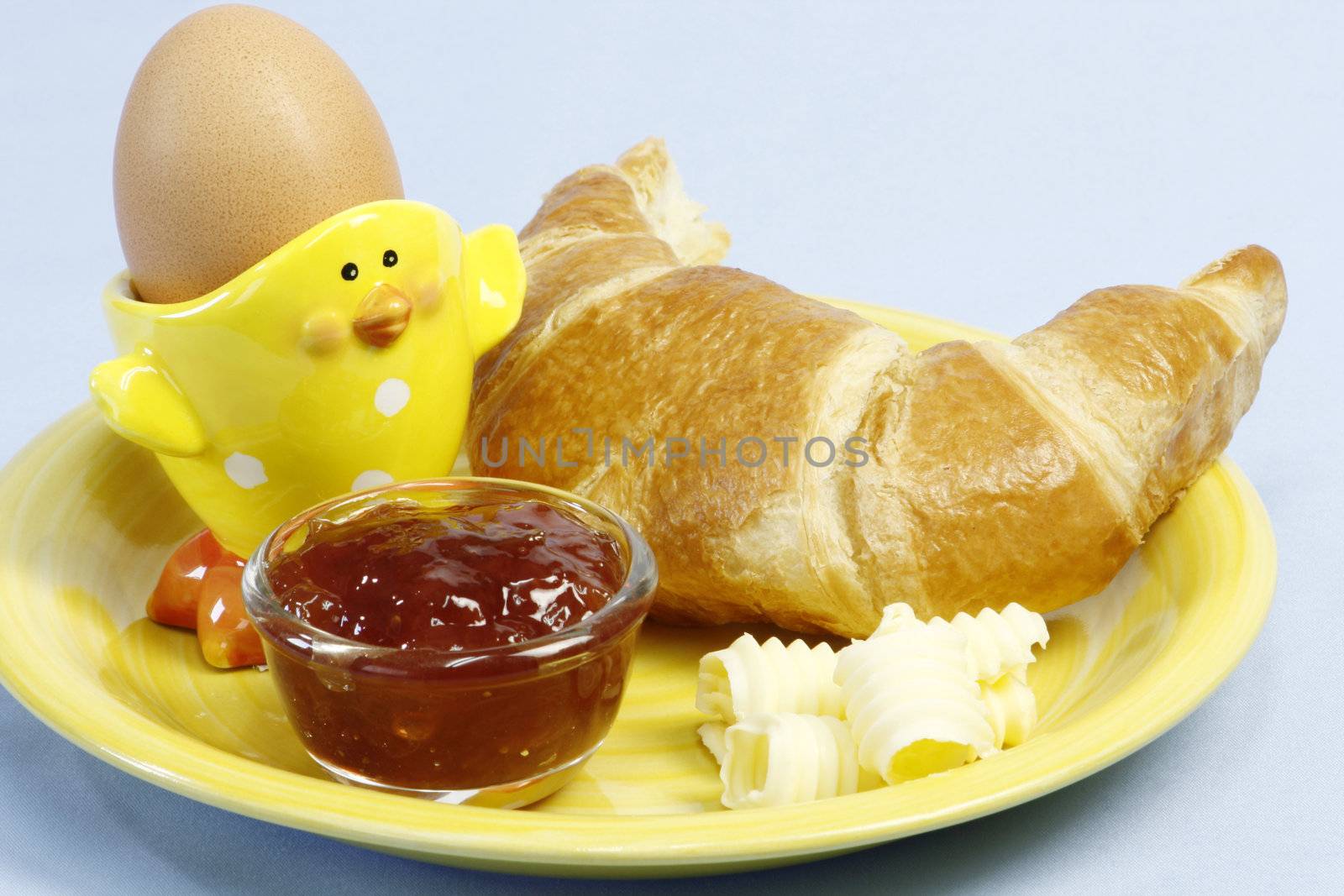 Croissant with butter and egg over light blue background