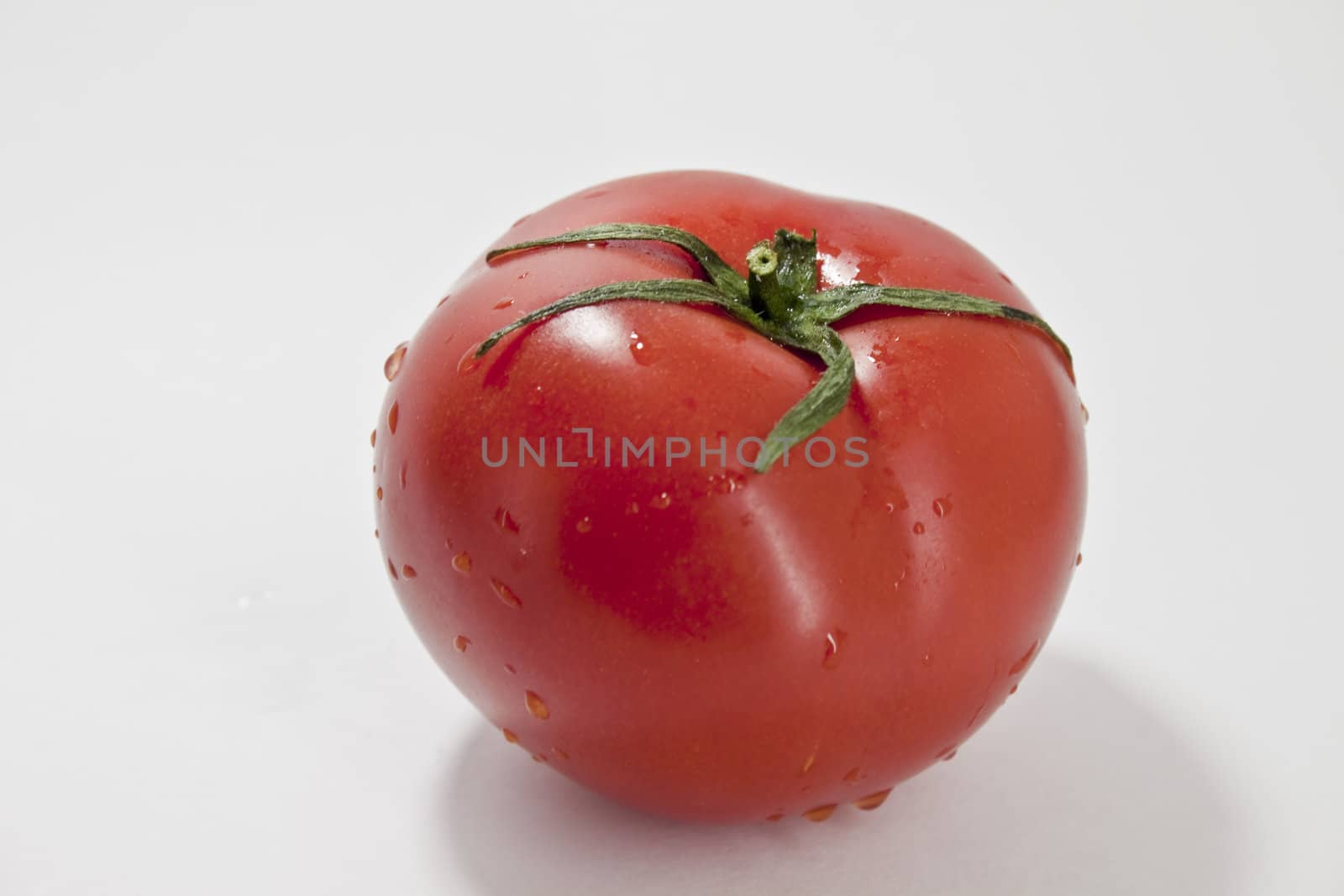 fresh red tomatoes in a heap on a light background