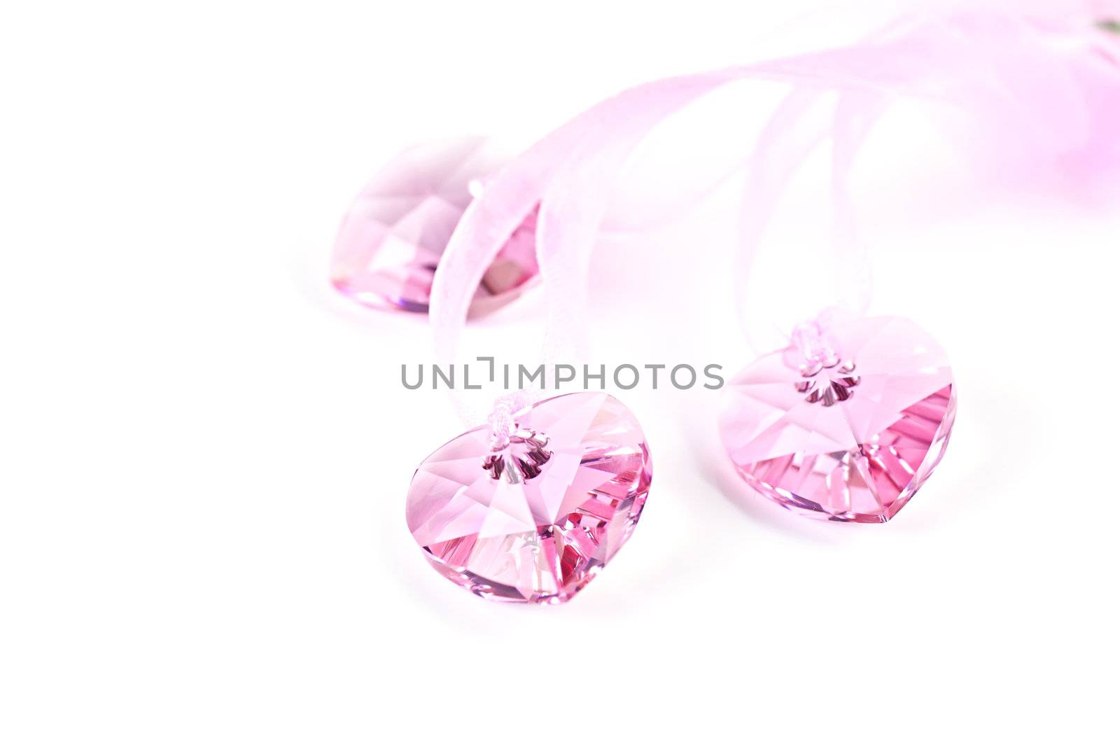 Three pink crystal hearts on a white background.