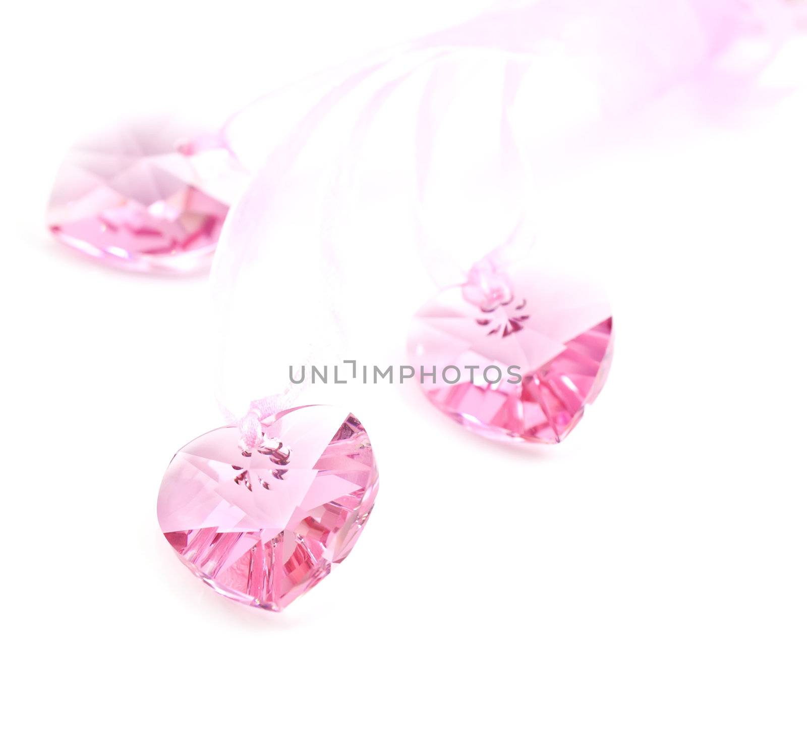 Three pink crystal hearts on a white background.
