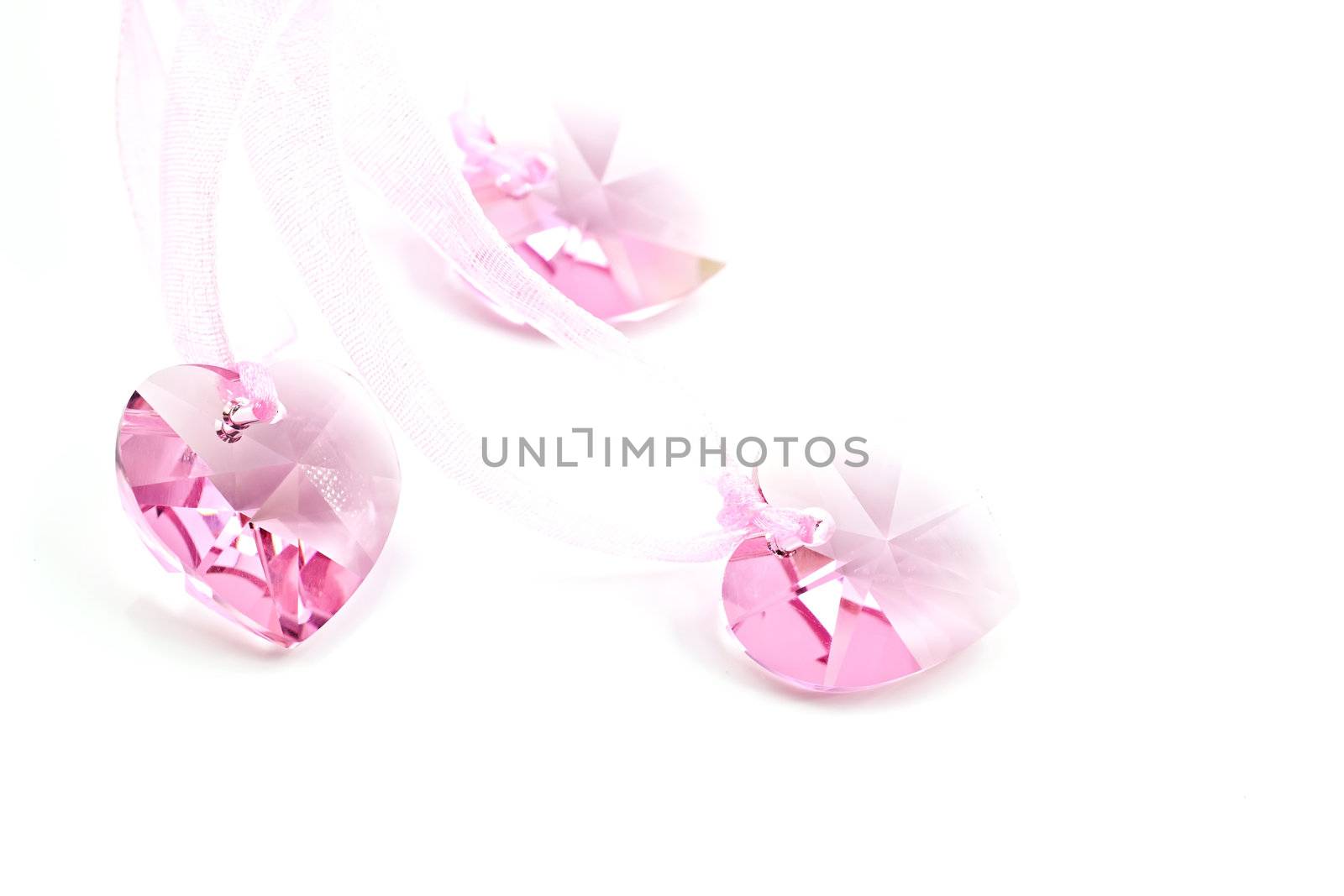 Three pink crystal hearts on a white background.
