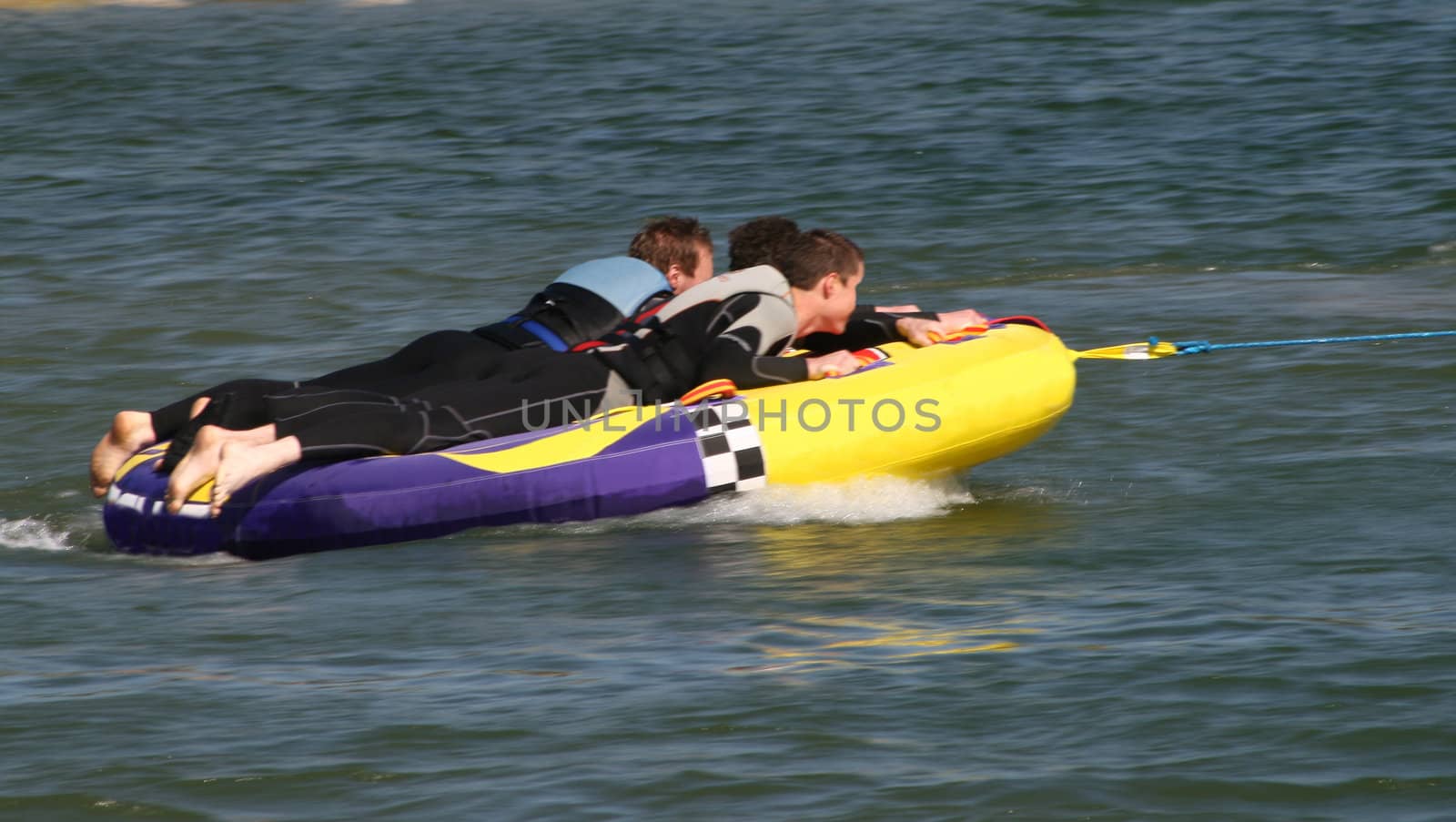 men being towed at speed on a water float
