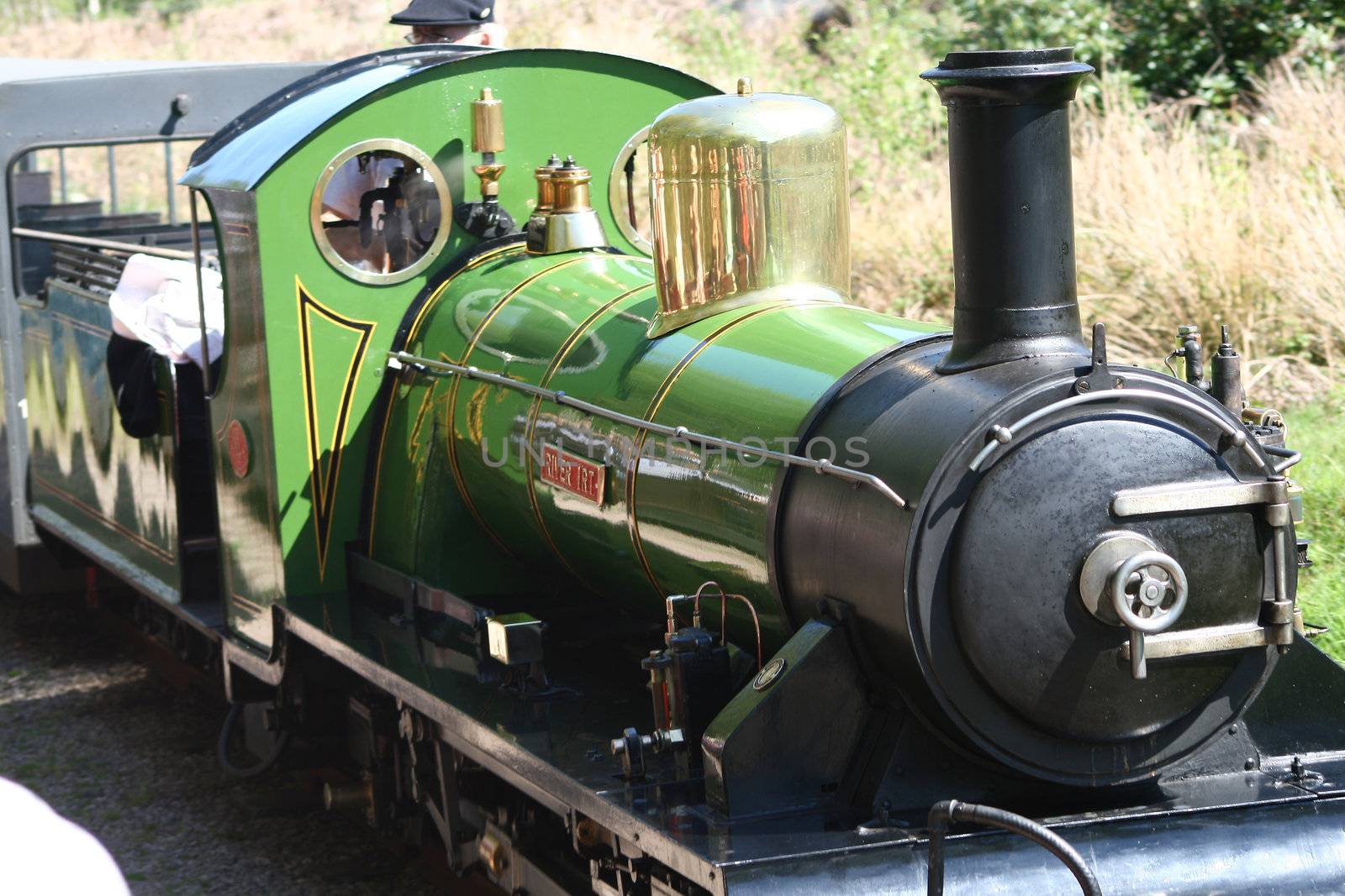 narrow gauge steam train being driven in the countryside
