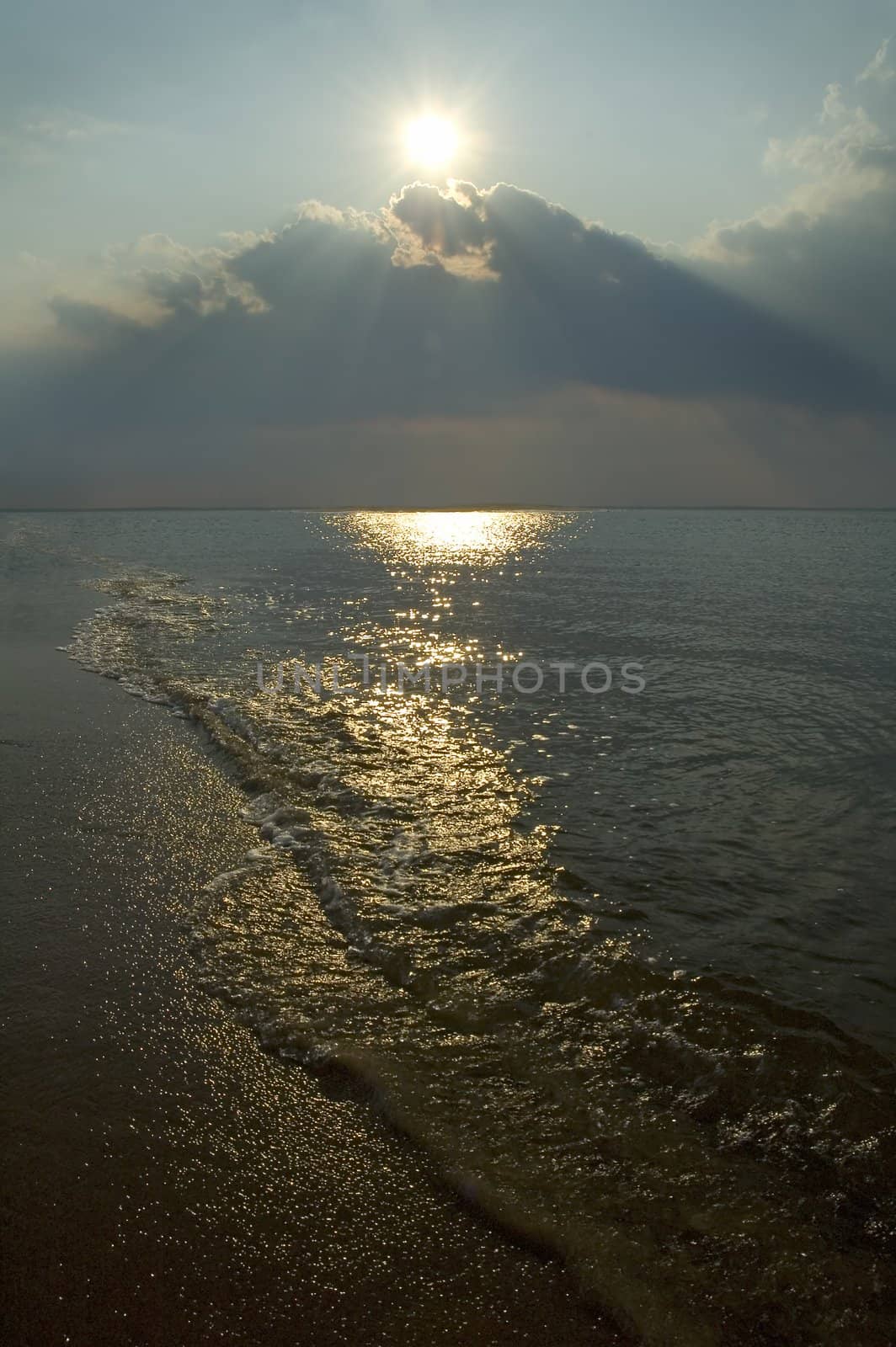 sandy beach, small water wave, direct sun light, dark dusk photo