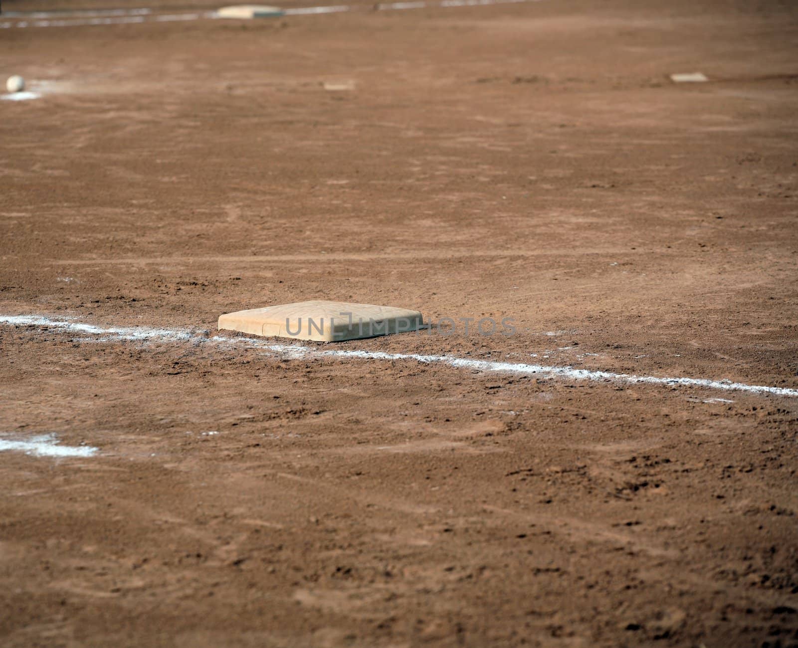 Sports field with 1st and 3rd bases showing.  Also the pitcher's mound and a ball