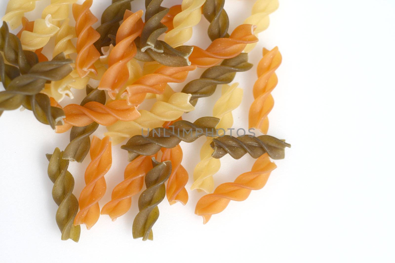 coloured pasta spirals over a light background