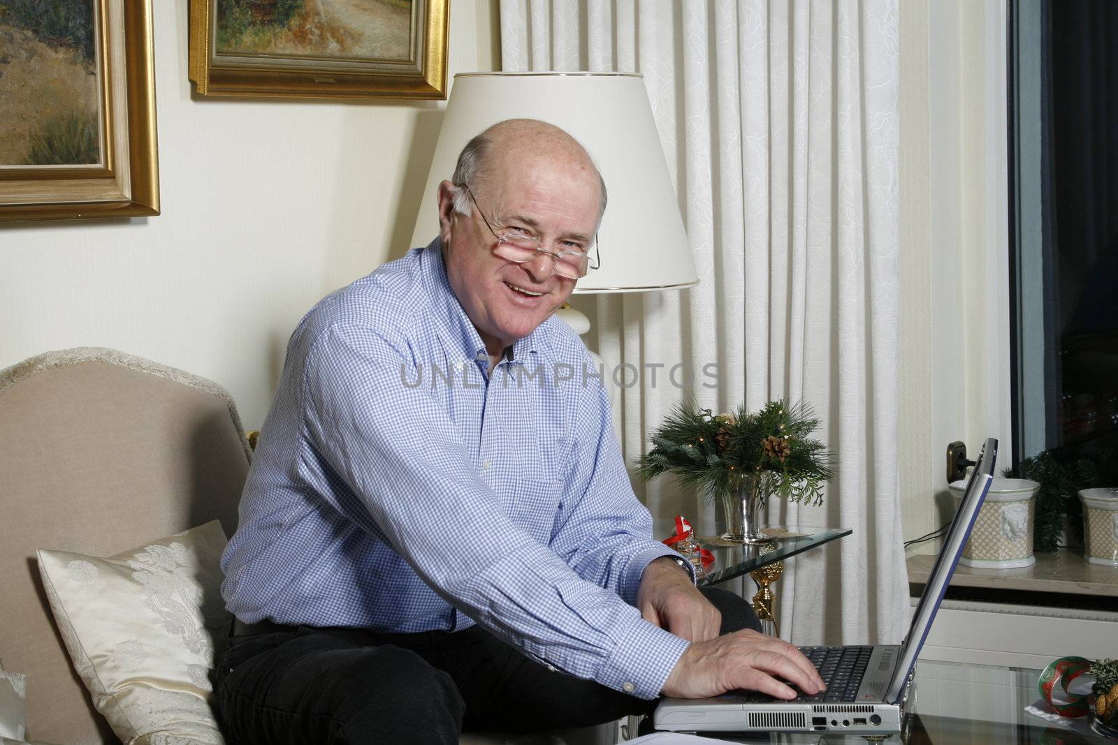 happy old  senior man with laptop at home