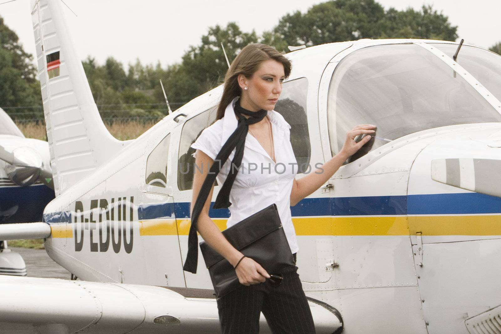 a young businesswomen at the airport in front off a private airplane