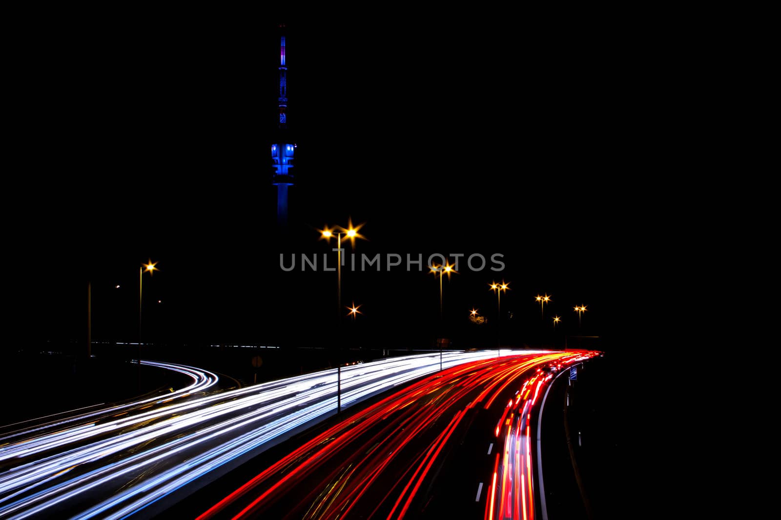 Time exposure photo with a street at night and automobile headlights of a multiple lane city street and a traffic light, Lisbon, Portuga