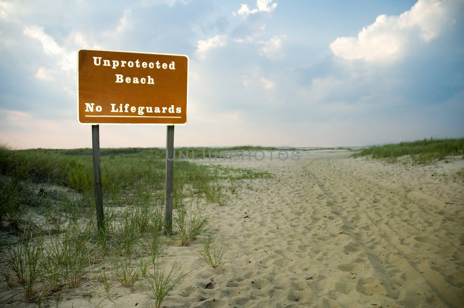 unprotected beach and no lifeguards sign, empty beach, 