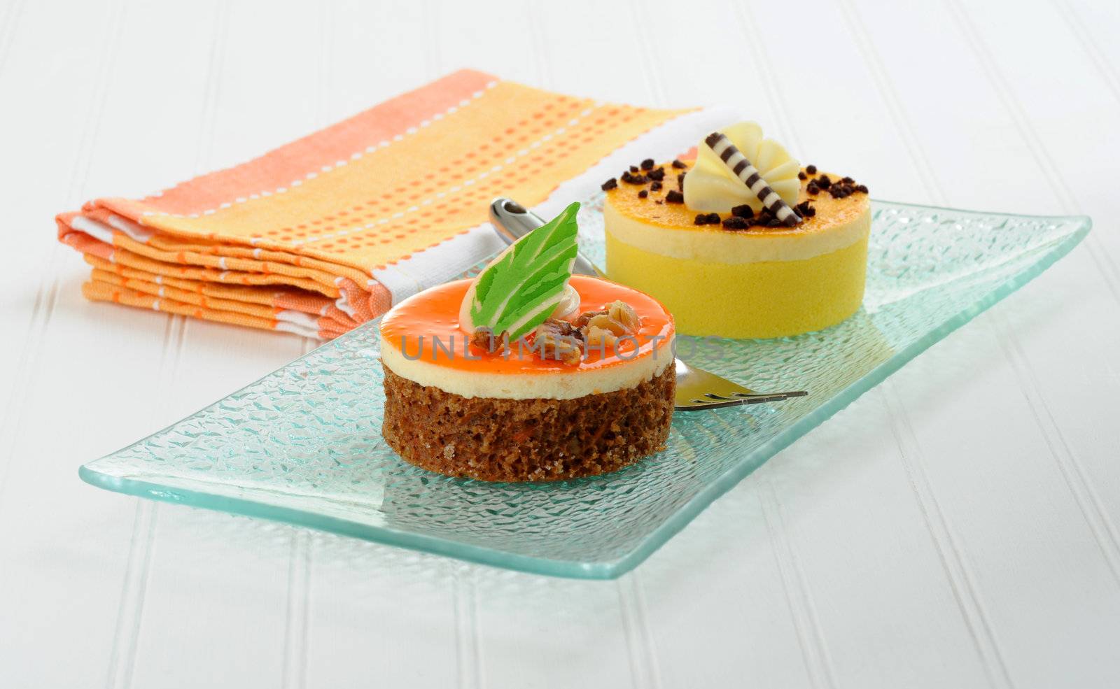 Colorful individual cakes on a glass dish.