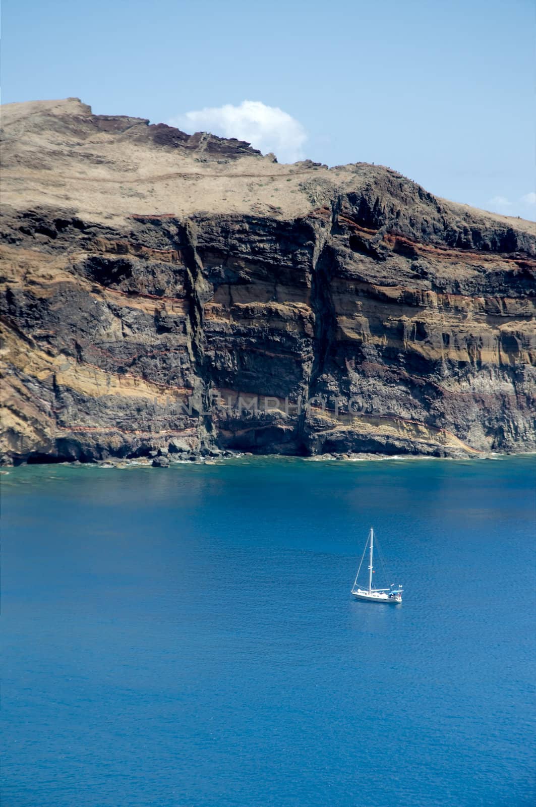 single sailboat in blue water of Madeira's south shore